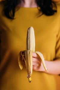 mujer sosteniendo un plátano pelado